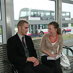 two adults sat at bus station
